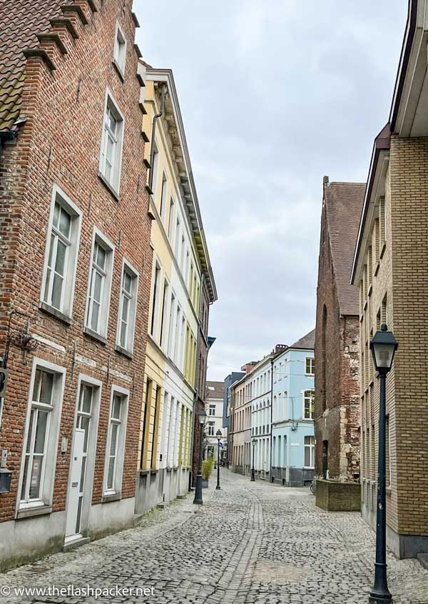 pretty old street in ghent belgium with redbrick and pastel terraced houses