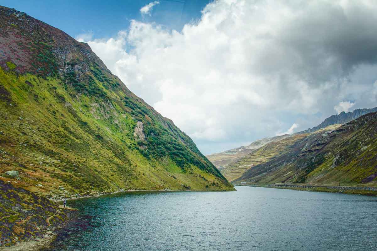 glacial river enclosed by small mountains in switzerland