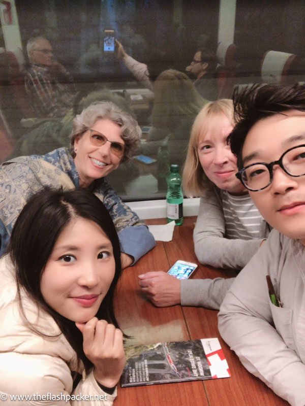 group of 4 people sitting around table on the glacier express switzerland