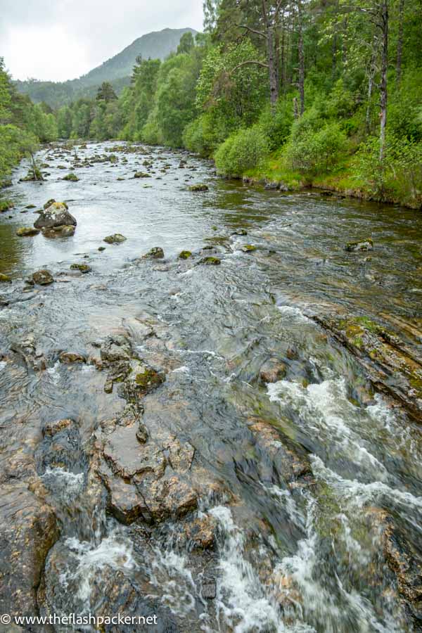 water cascading over rocks down a fast flowing river at glen affric scotland