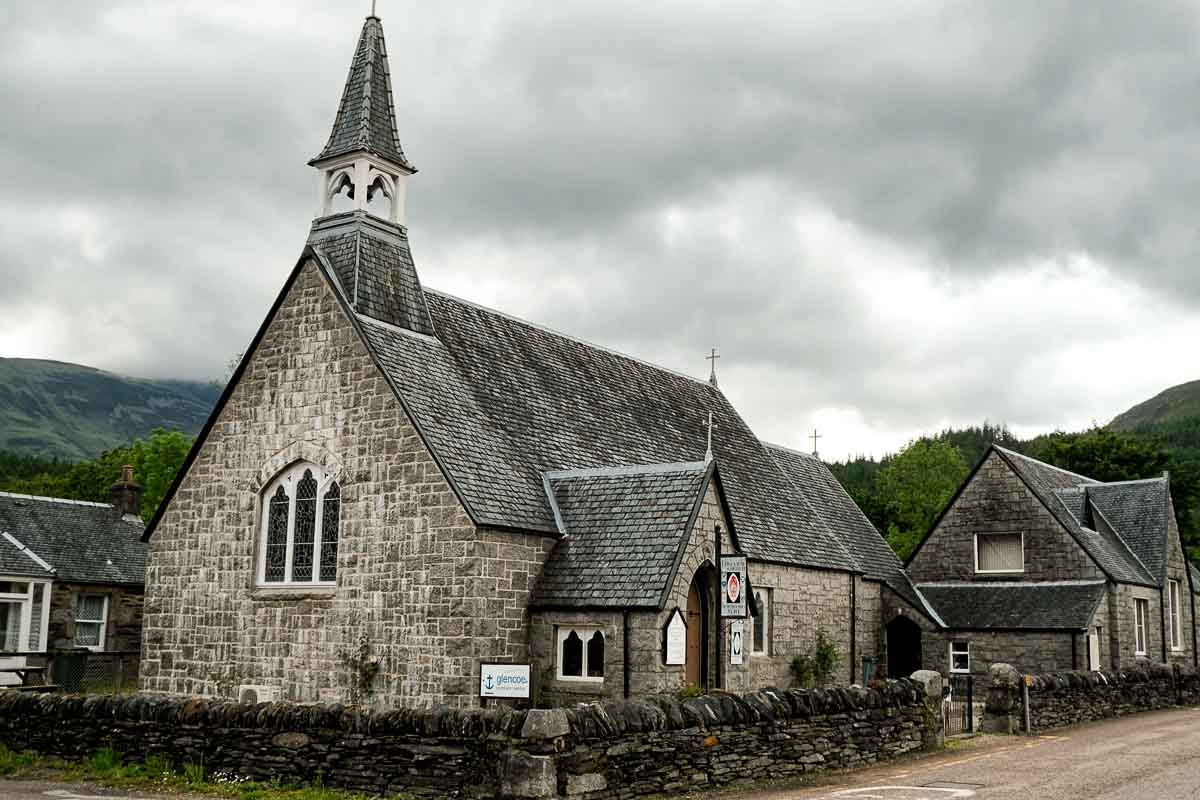 old grey stone church building on village street