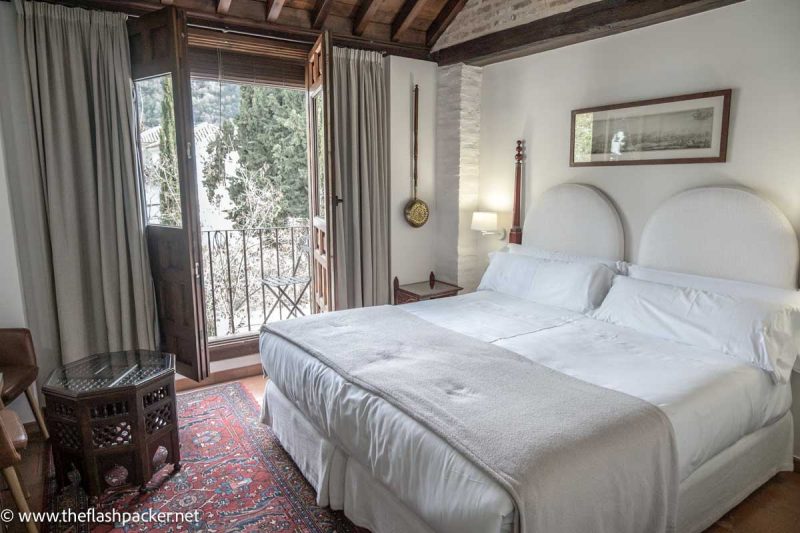 hotel bedroom with window opening to small balcony