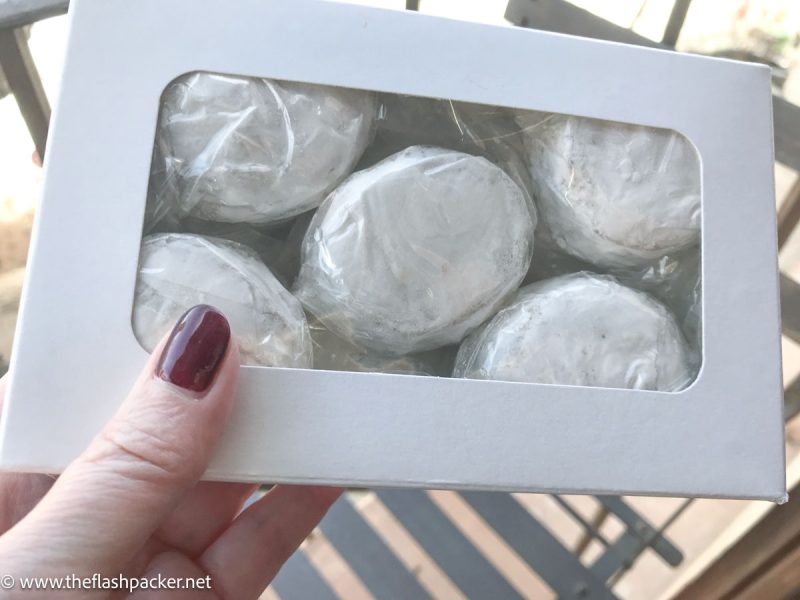 woman's hand holding box of wrapped cookies