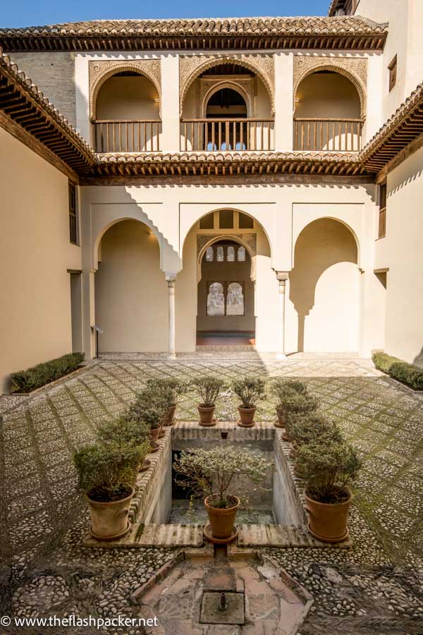 pretty arab courtyard with central dry pond surrounded by plants