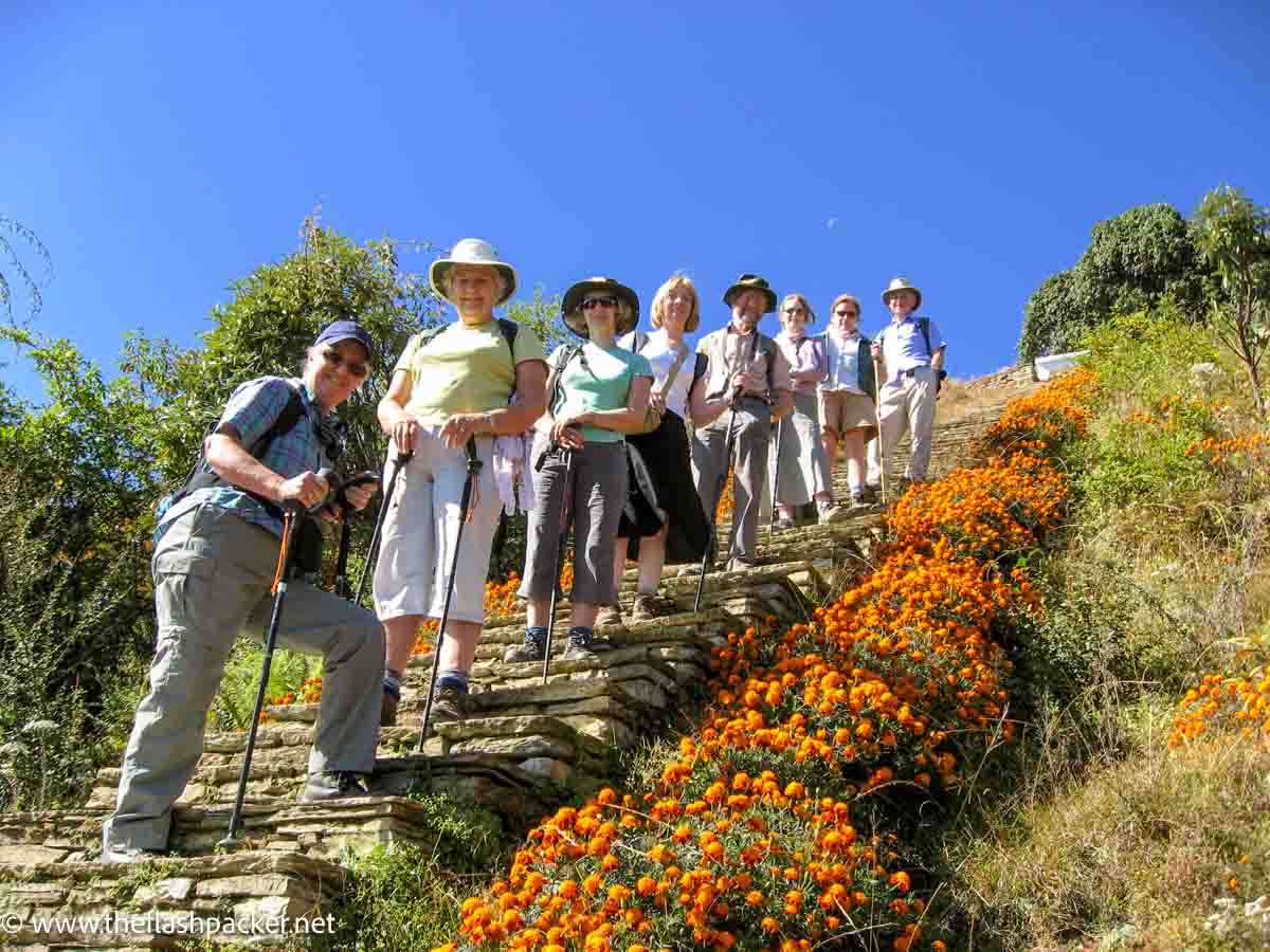 hikers who are part of a group travel for singles standing on stone steps against a deep blue sky