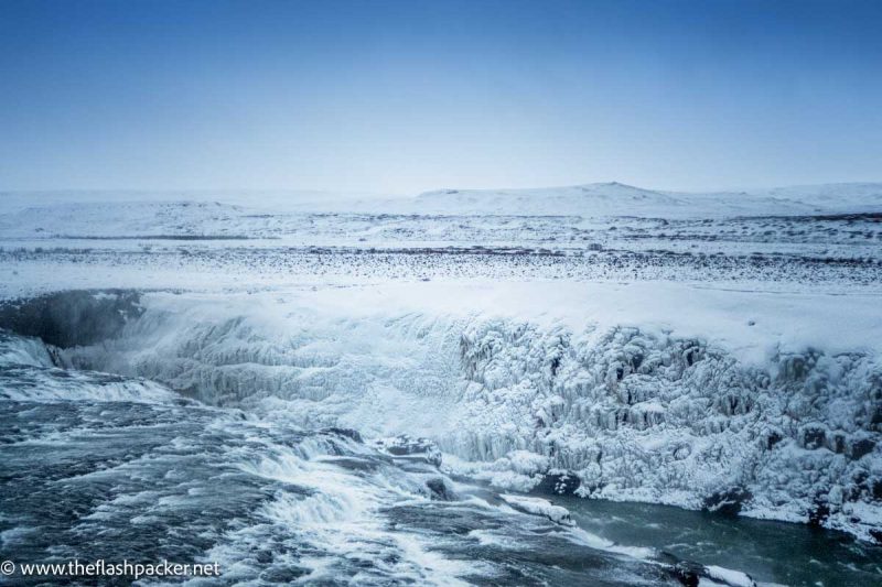 glacial water rushing through snow and ice covered landscape