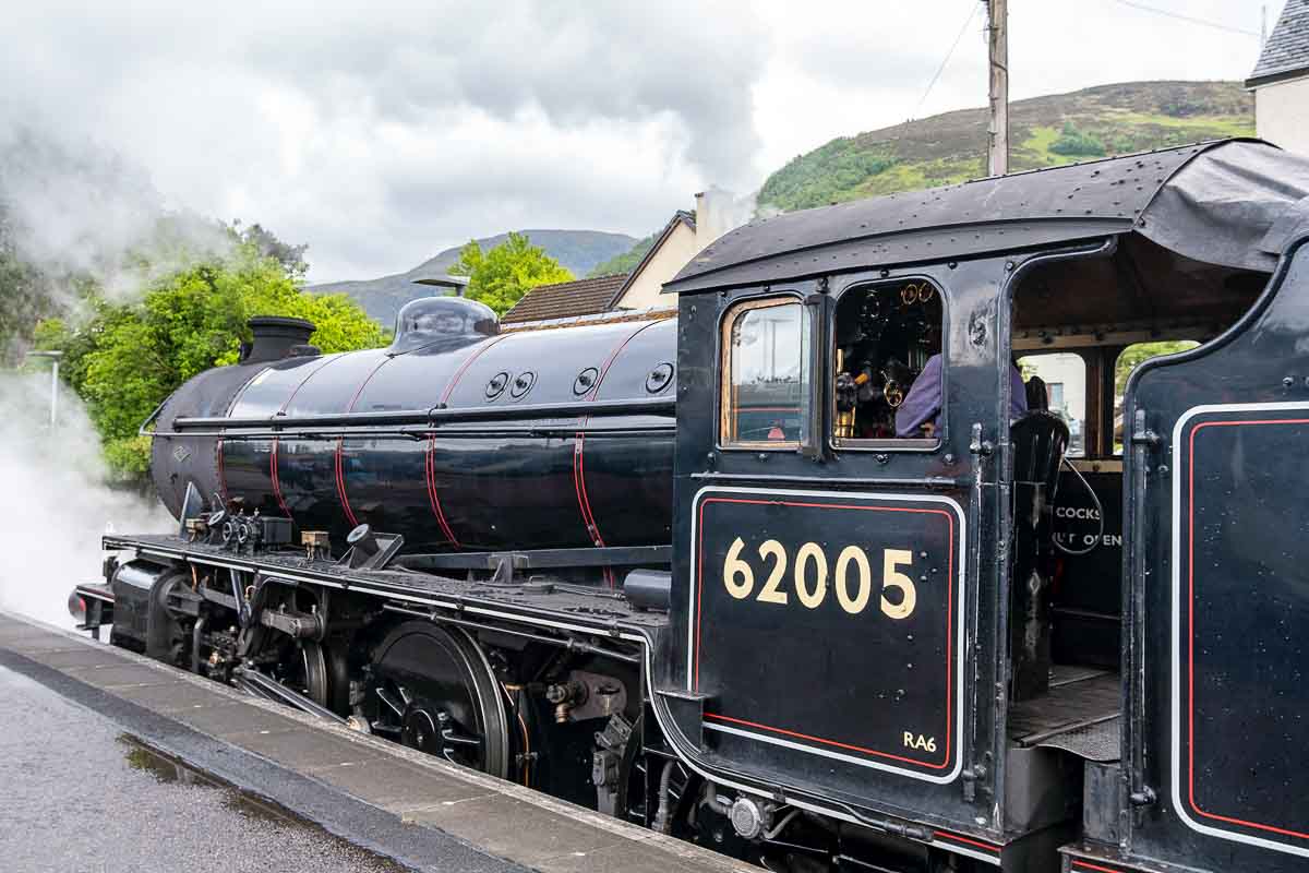 driver sitting in cabin of Jacobite steam train also known as the harry potter train in scotland