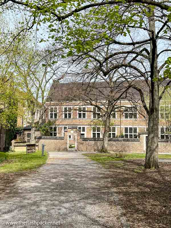 old red brick building of the beguinage of hasselt framed by branches of a tree