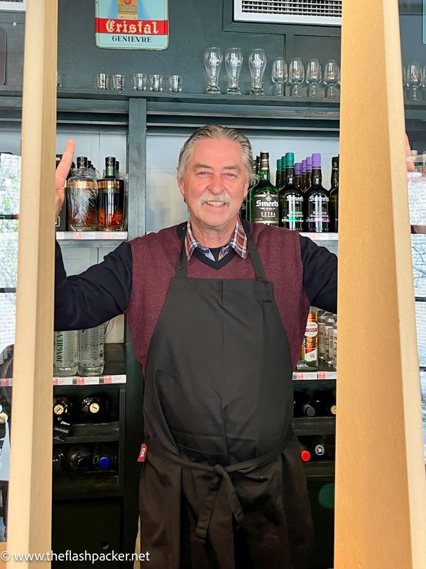 smiling man standinf in front of bar