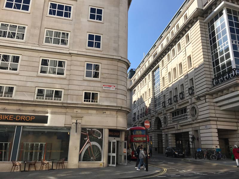 busy shopping street in london with red double decker bus