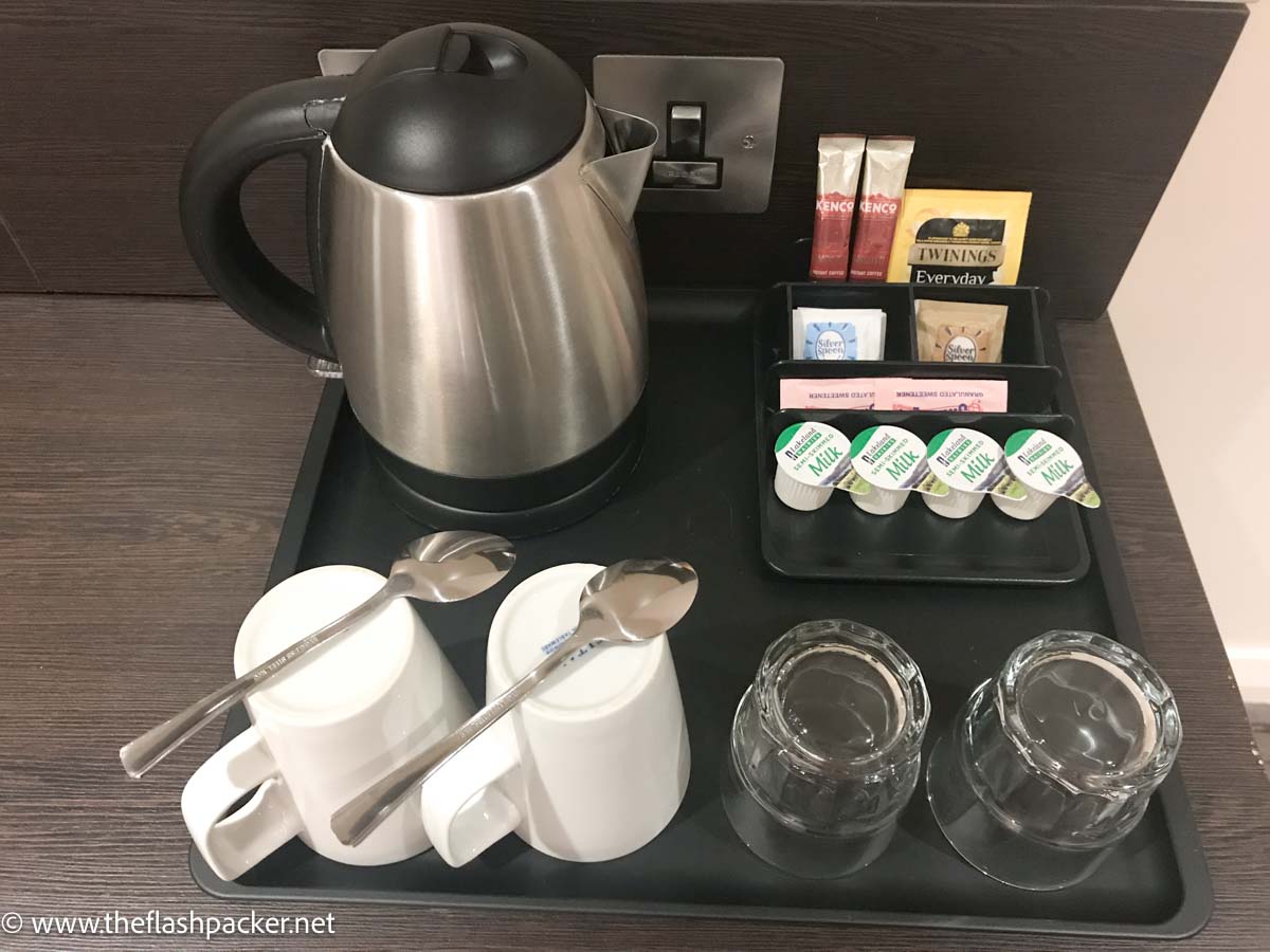 tray with kettle and cups and tea and coffee supplies