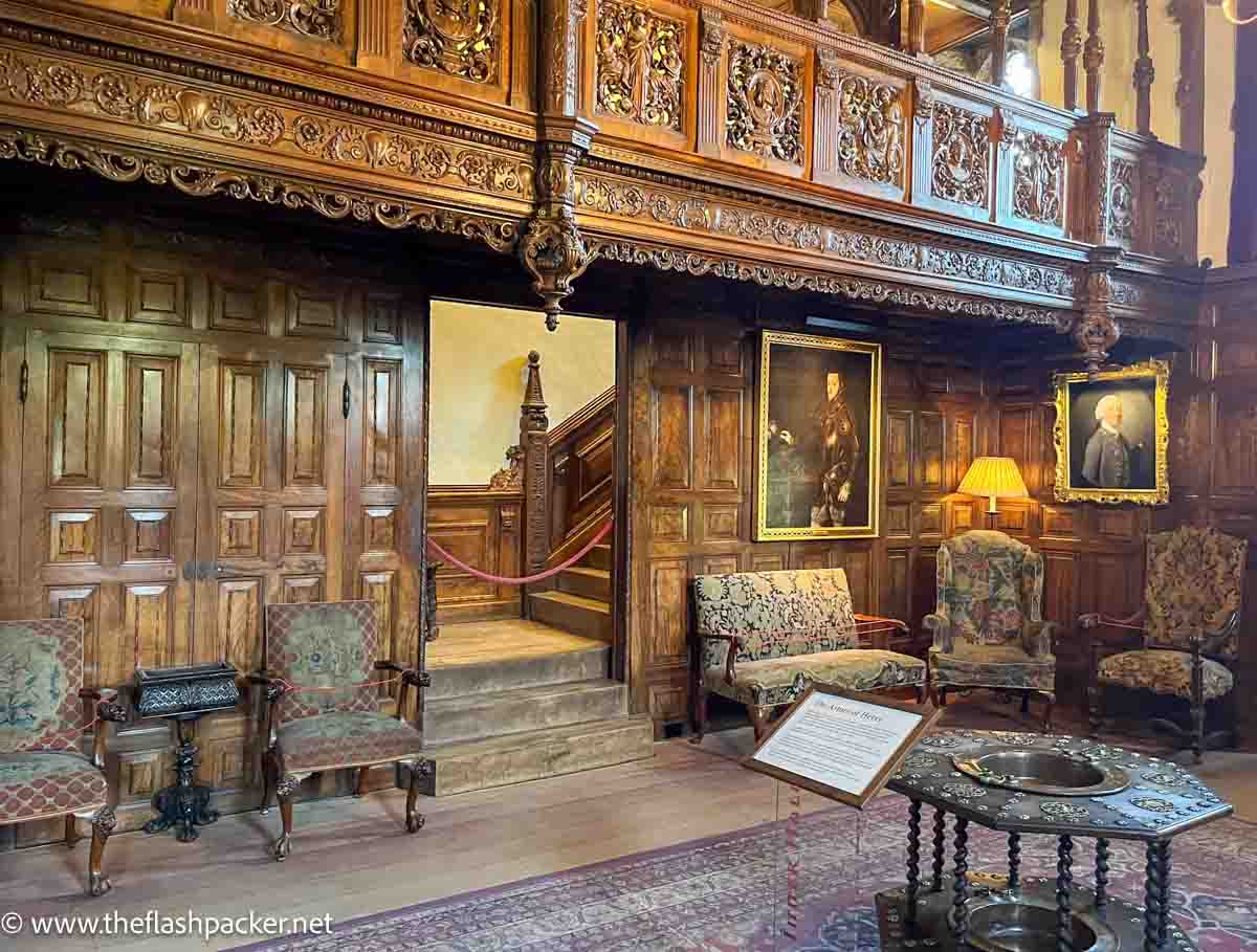 ornate room at hever castle kent with armchairs and carved wooden gallery