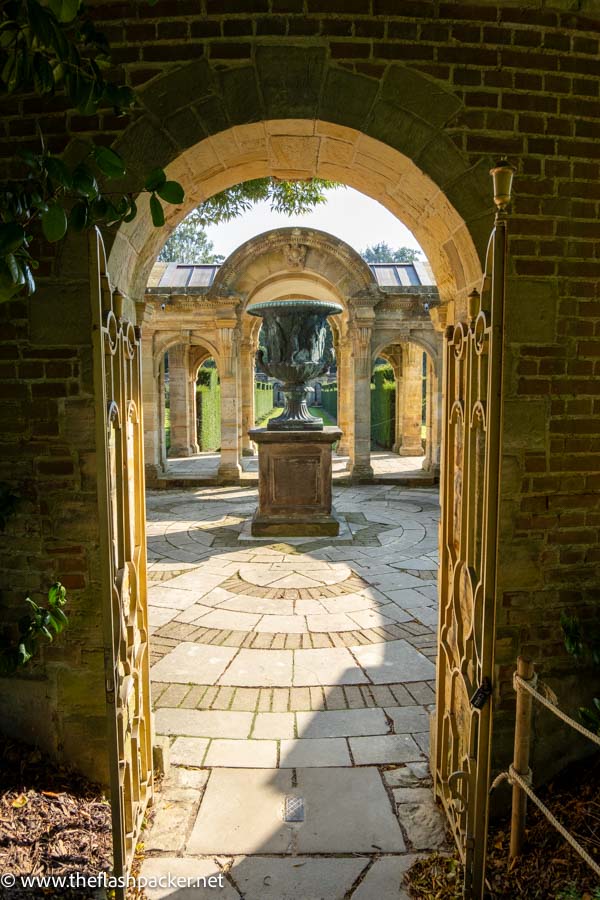 looking through an arched gateway into a small courtyard and garden