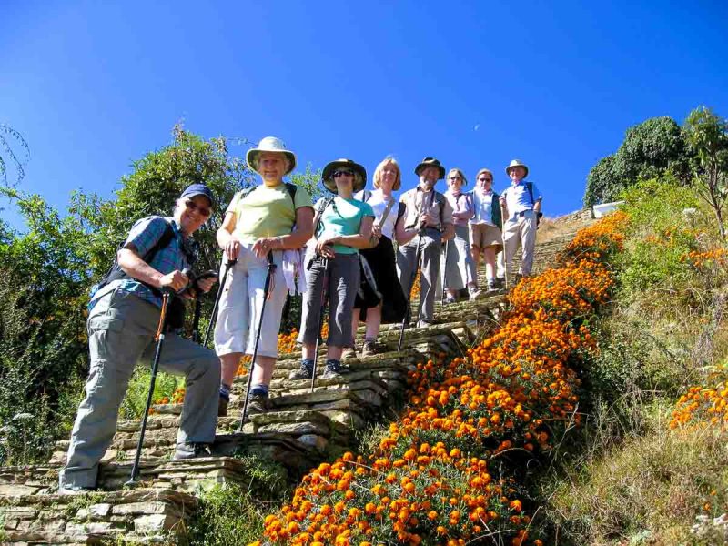 hikers who are part of a group travel for singles standing on stone steps against a deep blue sky