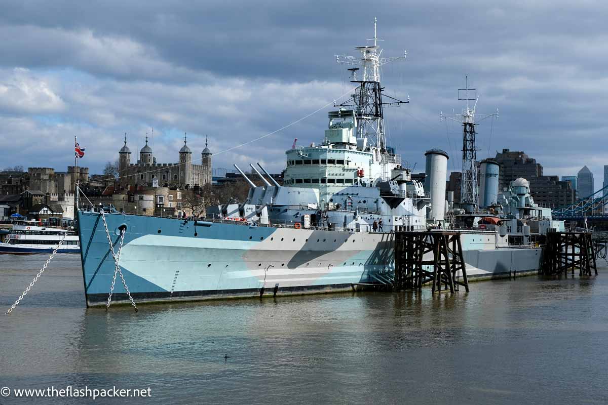 large blue and grey warship moored in river