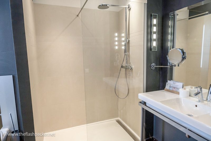 hotel bathroom with white sink and vanity unit and walk-in shower