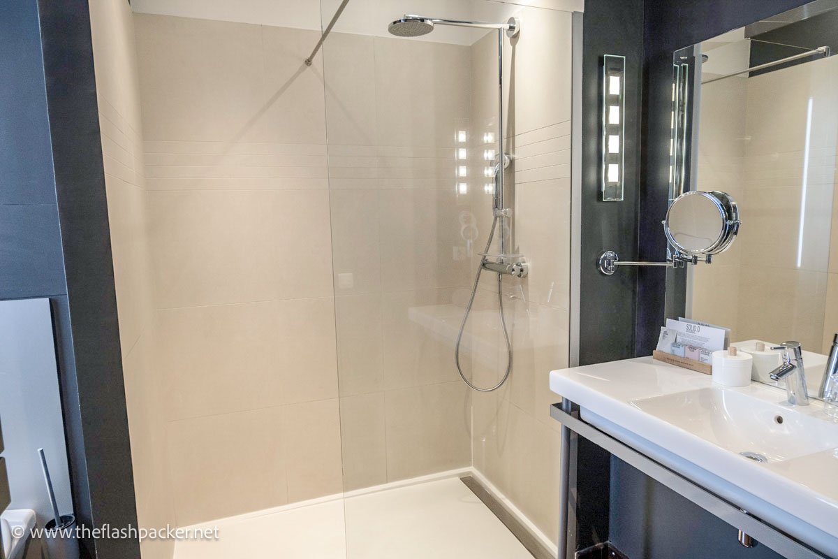 hotel bathroom with white sink and vanity unit and walk-in shower