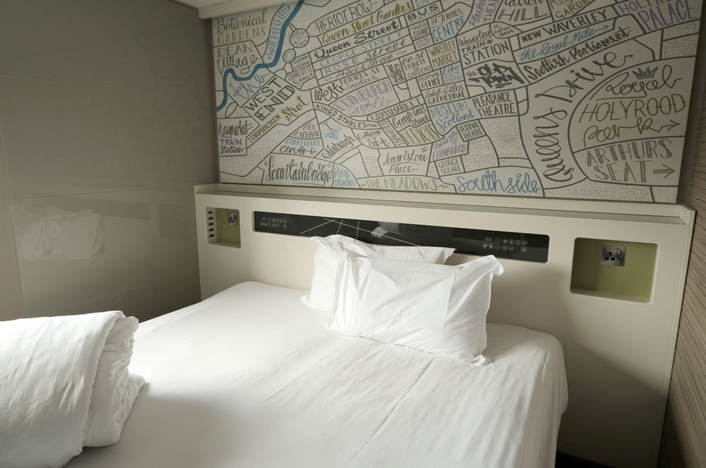 bed with white linen with large map above bed