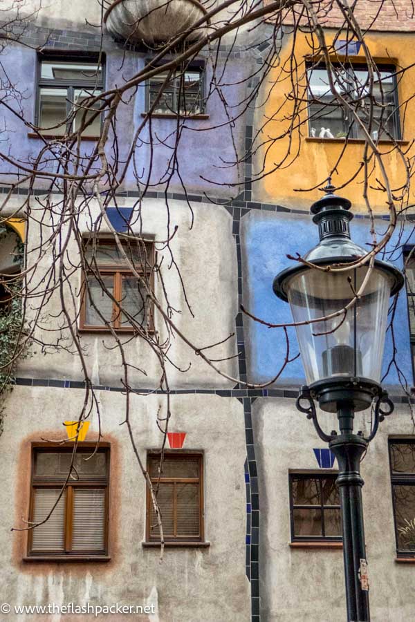 blue and grey and ochre higgledy piggeldy building with lampost