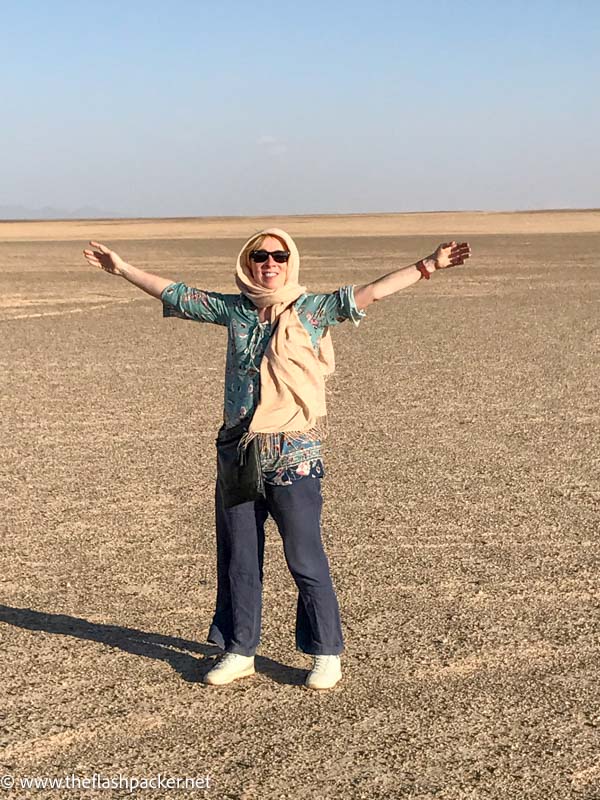 women with arms outstretched in desert