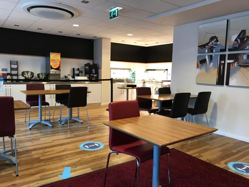 breakfast room in hotel with table and chairs and self service area