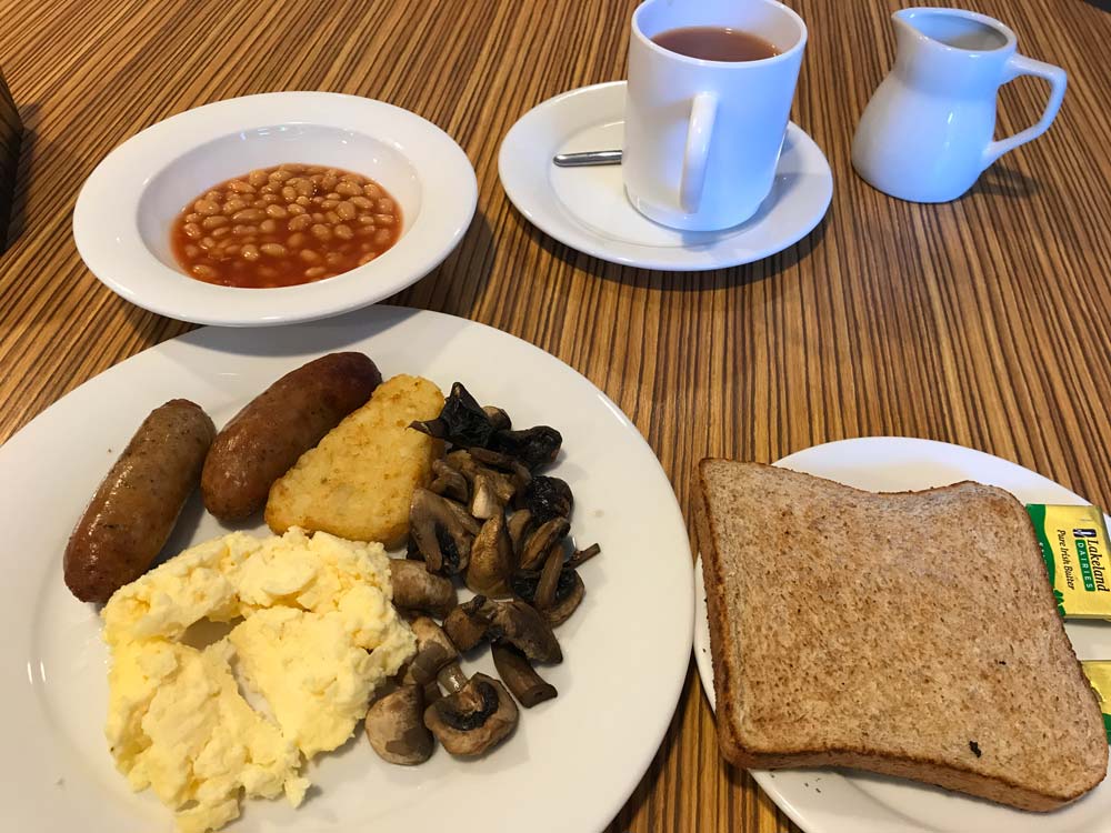 cooked breakfast with bowl of baked beans and mug of tea