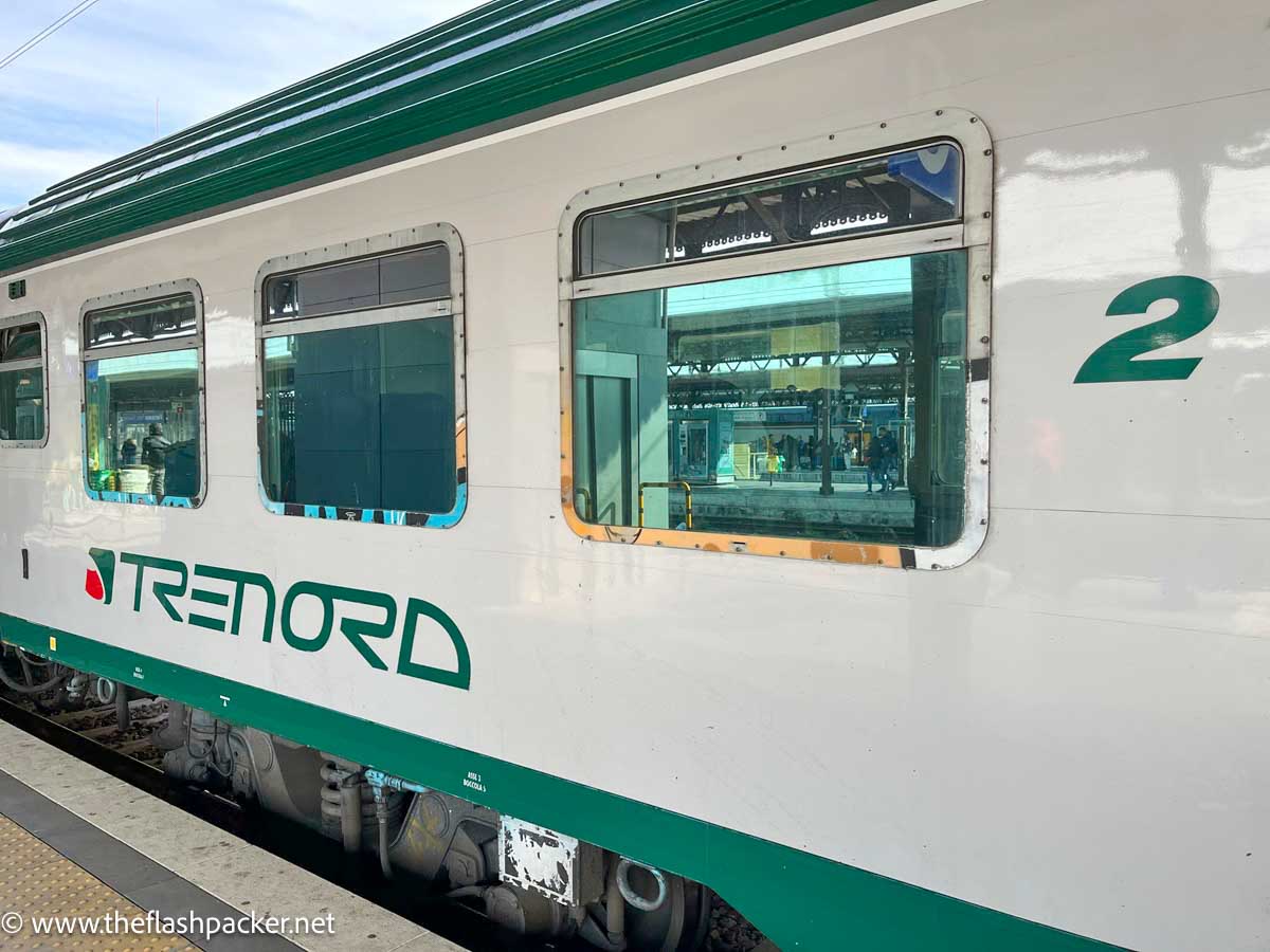 green and white exterior of a trenord train in italy