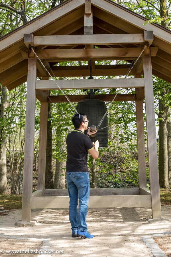 man ringing a japanese prayer bell