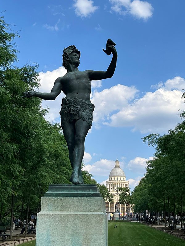 classical bronze statue with dome of the pantheon of paris in background