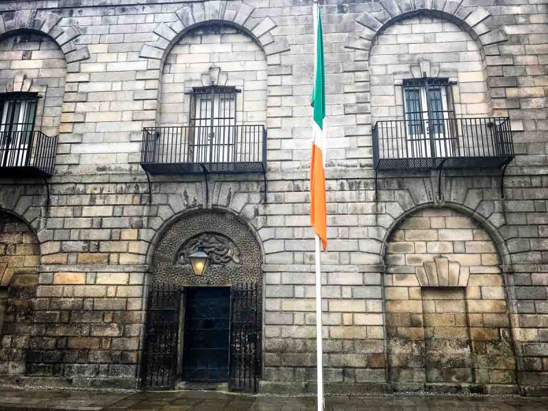 stone exterior of kiomainham gaol with tricolor flag