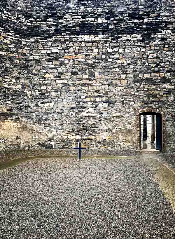 enclosed courtyard at kilmainham gaol with a wooden crucifix