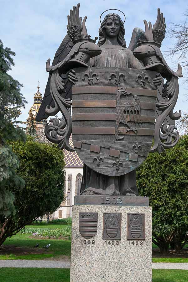 bronze coat of arm of the city of kosice held by an angel