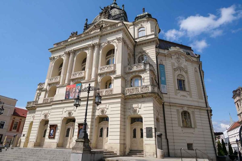 ornate cream brick exterior of kosice state theatre under a blue sky