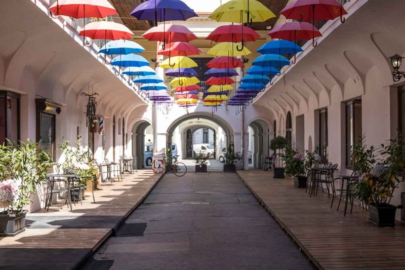 alley with a canopy of brightly coloured umbrellas