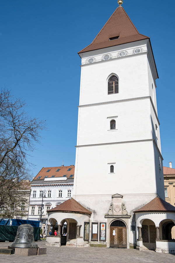 tall white rectangular bell tower with pitched tiled roof