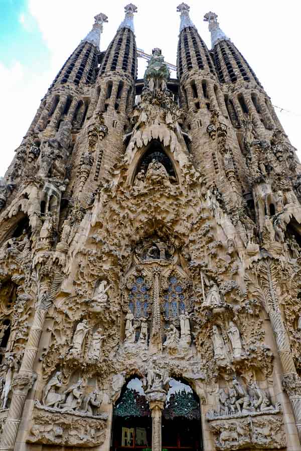 four towers and intricate carvings around entrance to La Sagrada Familia Barcelona