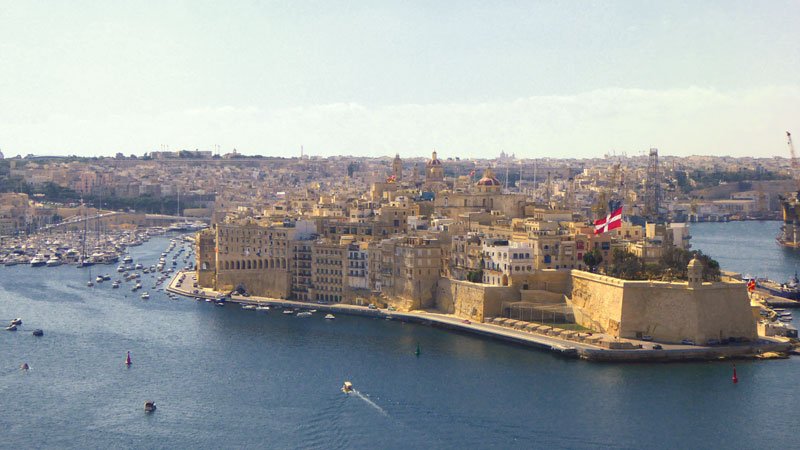 large harbous with small island with castle built from warm stone in valetta malta