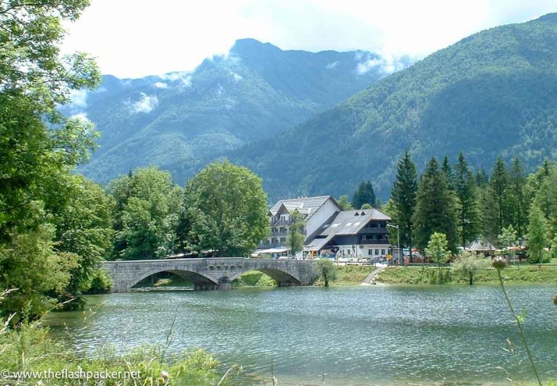 stone bridge across lake with mountains in background