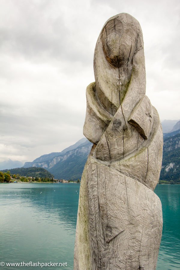 modern wooden sculpture of a woman by the side of lake brienz in switzerland