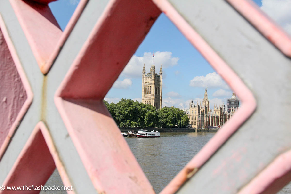 gothic tower and palace of westminster viewed through pink and grey opening