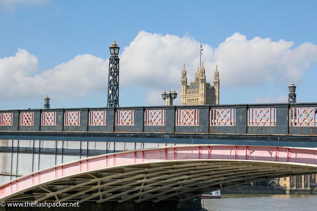 pink and grey bridge with gothic tower in background