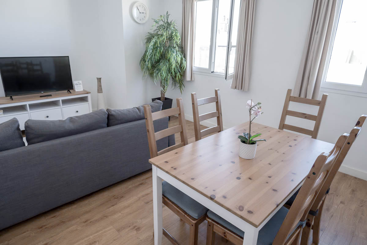 lounge in a rental apartment with a table and 5 chairs, sofa and tv