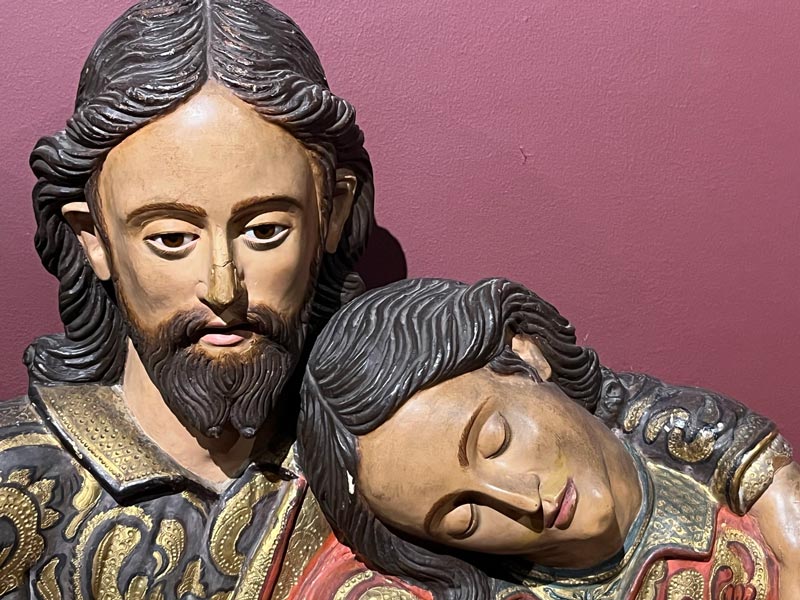 wooden sculpture of Jesus and disciple resting on his shoulder