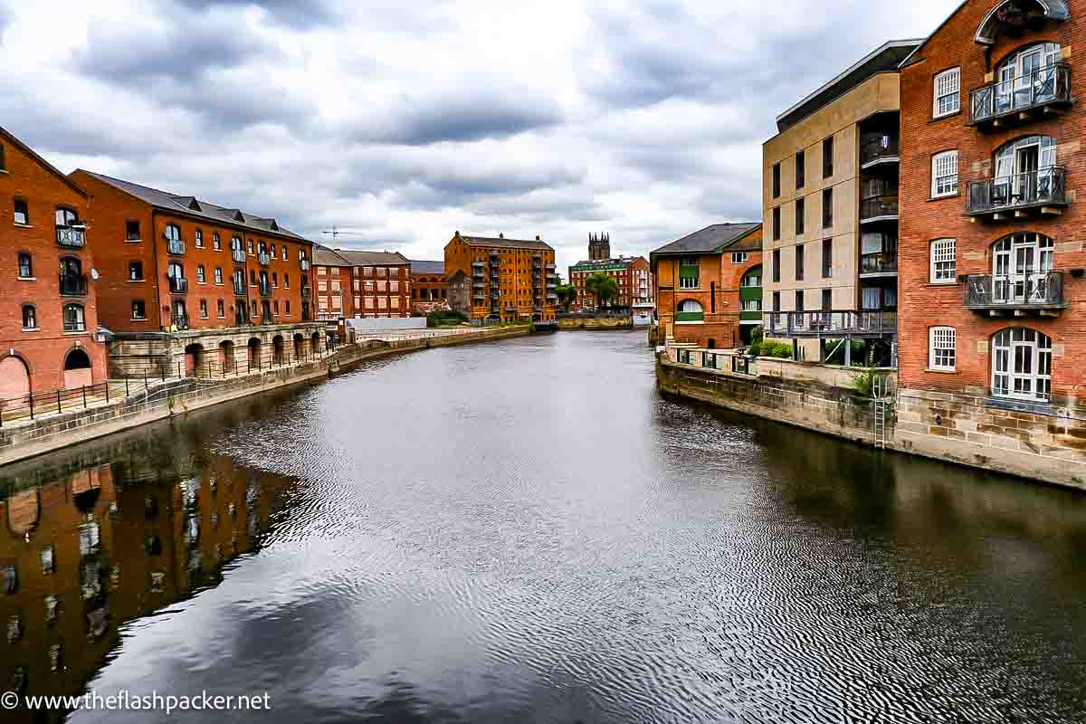 red brick buildings lining river in leeds