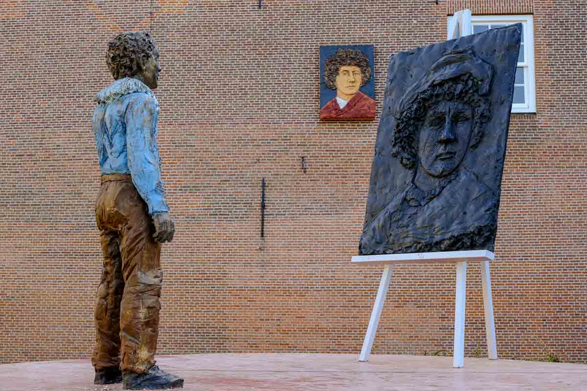 sculpture of young boy in front of an artist's easel