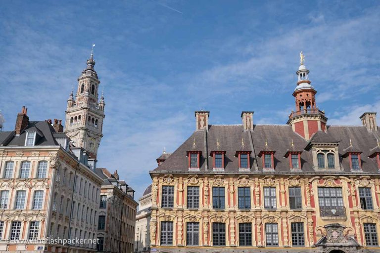 flamboyant flemish buildings in front of a bell tower in lillle france