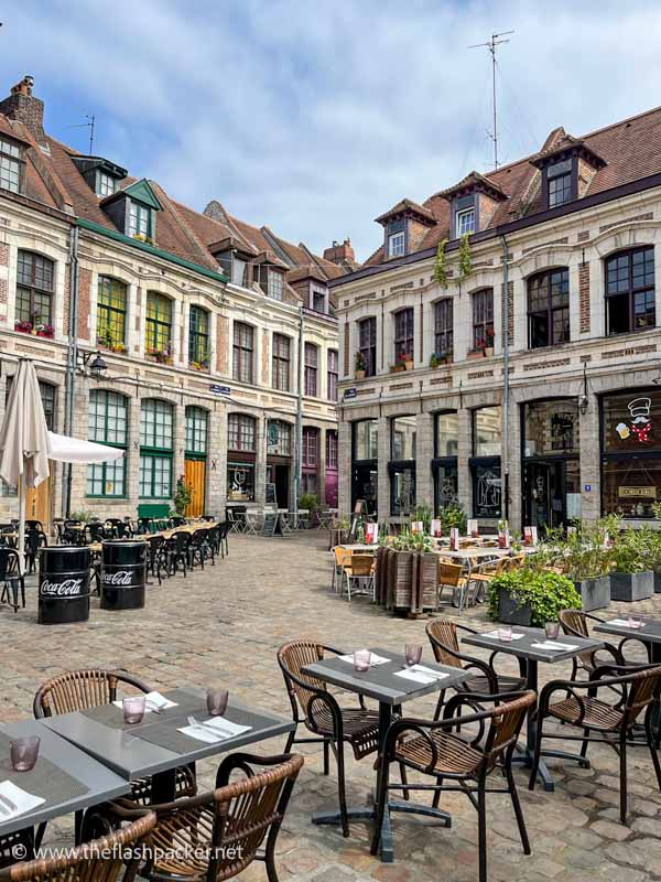 photogenic small square occupied by restaurant tables and chairs