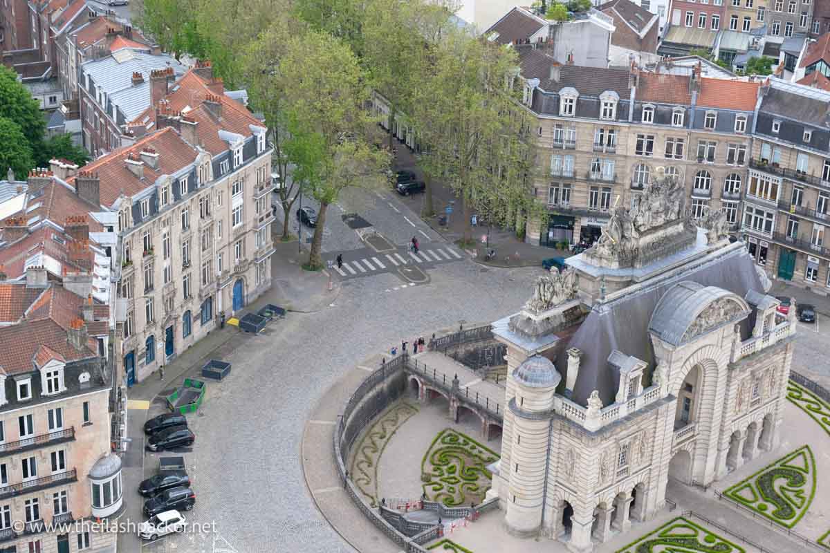 aerial view of a monumental gate encircled by a road and 4-storey buildings