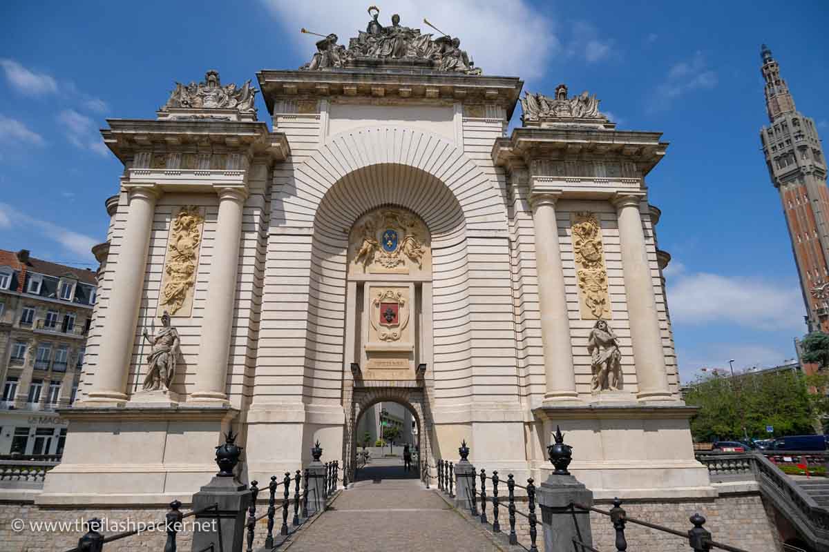 monumental gate and arch with a bell tower to its right