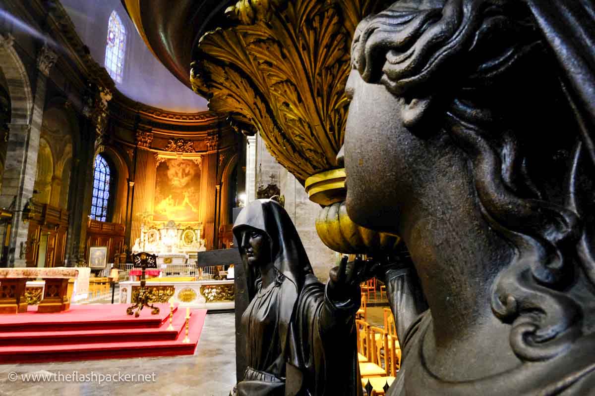 statue of angel in front of a church altar